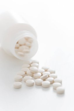 Beyaz arka planda şişedeki hapların yakın plan görüntüsü      