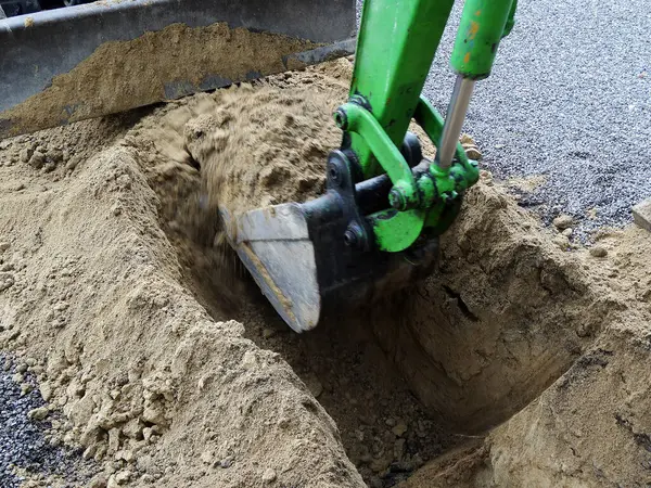 İnşaat alanında kumlu toprak kazan yeşil kazıcı