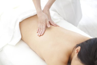 Kaplıcada masaj yapan genç bir kadın.