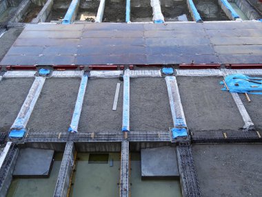 İnşaat alanı beton levhalar ve metal takviyeleri gösteriyor.