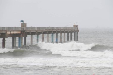 Büyük fırtınalı dalgalar iskeleye çarpar.