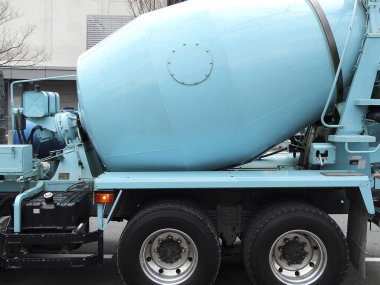 Şehrin caddesinde mavi çimento karıştırıcı kamyonu var.