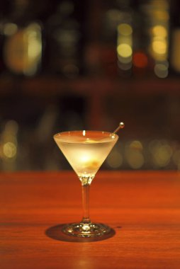 Masada berrak sıvıyla dolu martini bardağı.