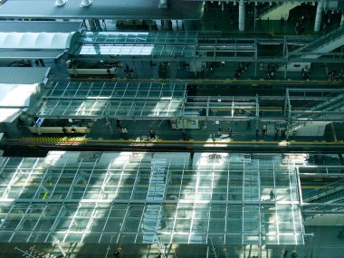 Güneş ışığı büyük tren istasyonunda modern cam çatıdan akıyor.