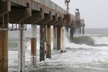 Büyük fırtınalı dalgalar iskeleye çarpar.
