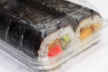 Japon suşisi plastik kabın içinde yuvarlanıyor. 
