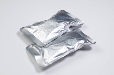Beyaz arkaplanda izole edilmiş alüminyum folyo paketleri