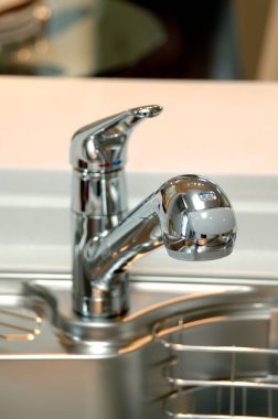 Modern mutfaktaki musluk ve paslanmaz çelik lavabonun manzarasını kapat.