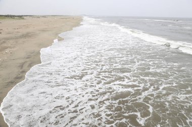 Okyanustaki kumlu sahilde dalgalar