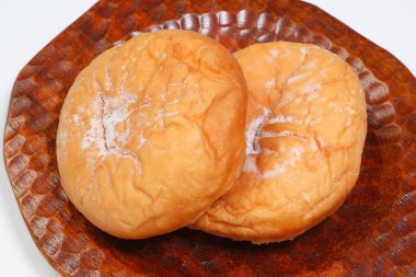 Arkaplanda lezzetli çörekler olan ahşap bir kase.