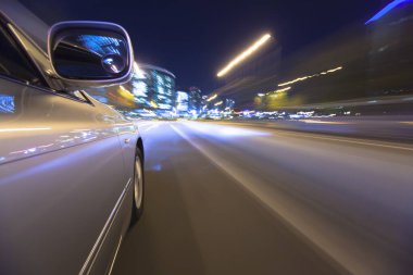 Gece şehir caddesinde araba sürüyor. Hareket bulanıklığı