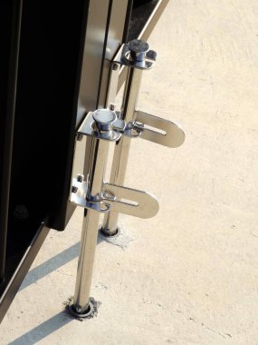 Parlak metal kapı mandalları dikey direklerin güvenliğini sağlıyor.