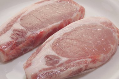 Beyaz arkaplanda çiğ etin yakın plan görüntüsü.                   