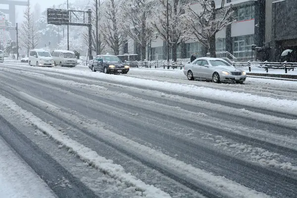 Kış şehrinde karla kaplı yolda trafik