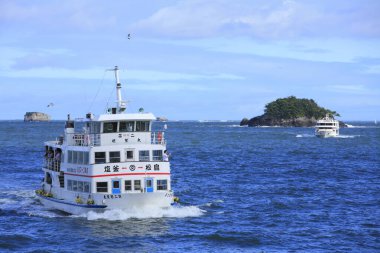 ship approaching rocky islands with lush green vegetation. Matsushima islands in Miyagi Prefecture, Japan clipart