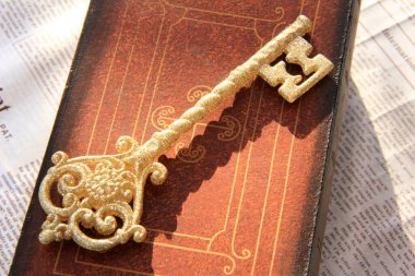 Kitabın üzerinde altın anahtar 