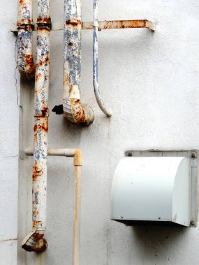 Binadaki eski paslı metal boruların yakın çekim görüntüsü  