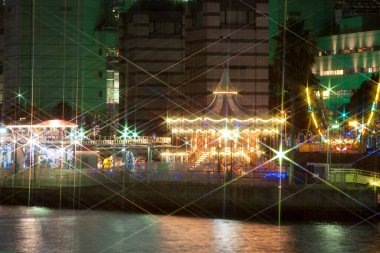 Şehrin arka planında renkli noel ışıkları var.