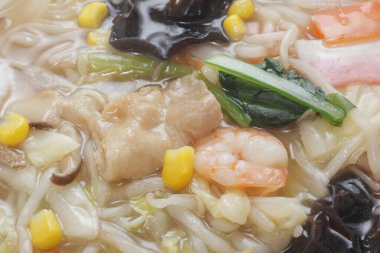 Çorba içinde deniz ürünleri, erişte ve sebze.