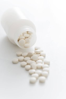 Beyaz arka planda şişedeki hapların yakın plan görüntüsü      