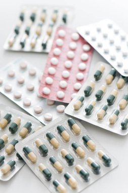 Beyaz arka planda farklı haplar, yakın plan.