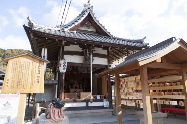 Geleneksel Japon tapınağı binası ağaçlar ve gökyüzüyle çevrili.