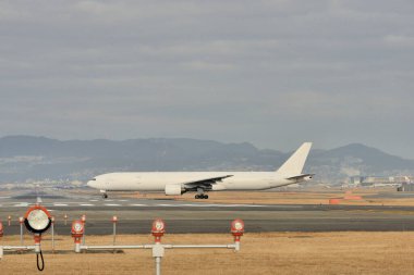 bulutlu mavi gökyüzünün arka planına inen uçak
