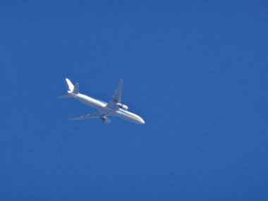 Beyaz yolcu uçağı mavi gökyüzünde uçar