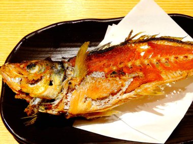 Grilled fish served on black plate