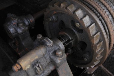 Yakın plan, kalın kablolu paslı endüstriyel dişli mekanizmasını gösteriyor.