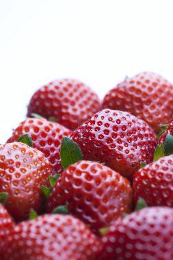 Beyaz arka planda taze olgun çileklerin yakın plan görüntüsü           