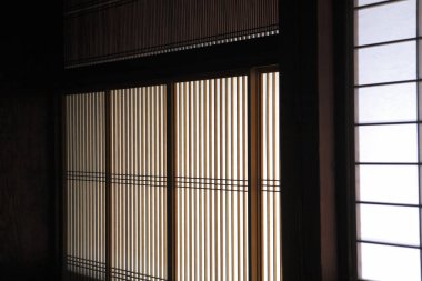 Japon tarzı pencereler, güneş ışığı ve içinde ahşap elementler var.