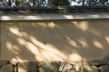 Güneş ışığı, geleneksel taş duvarlar boyunca yumuşak gölgeler bırakıyor.