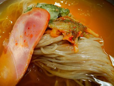 Etli, sebzeli ve erişteli leziz bir Asya yemeğinin kapağını kapat.