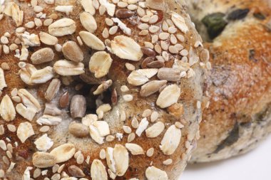 Yakından bakınca üzerinde tohum ve yulaf olan iki tane çoklu tahıllı simit görünüyor.