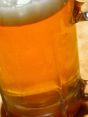 Bardaki masanın üzerindeki bira bardağının yakın plan görüntüsü.