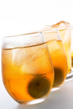 Beyaz zemin üzerinde alkol ve buz küpleri olan bardaklar.                   