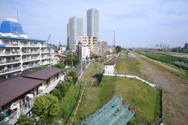 modern şehir binaları, yeşil ağaçlar ve mavi gökyüzü