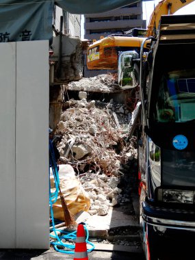 Dışarıda park halindeki inşaat araçları arasında beton moloz yığını var.
