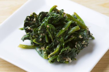 Beyaz tabakta kızartılmış ıspanak