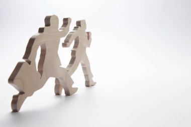 Beyaz arka planda iş adamlarının ahşap figürleri.