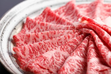 Tabaktaki lezzetli wagyu sığır eti dilimlerinin yakın görüntüsü        