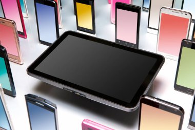 Gri arkaplanda farklı modern akıllı telefonların ve dijital tabletin yakın plan görüntüsü.                  