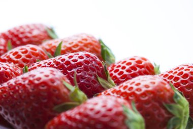 Beyaz arka planda taze olgun çileklerin yakın plan görüntüsü           