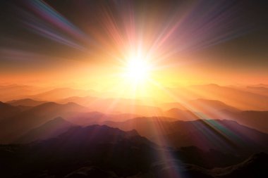 Güneş bir dağ sırasının üzerinde parlak bir şekilde batıyor.    