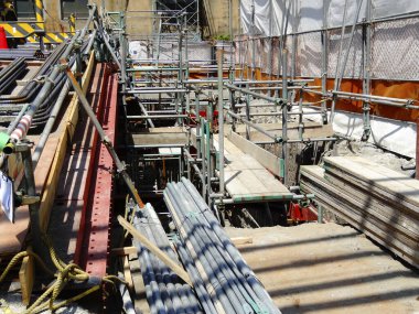 İnşaat sahasında iskeleler ve çeşitli yapı malzemeleri var.