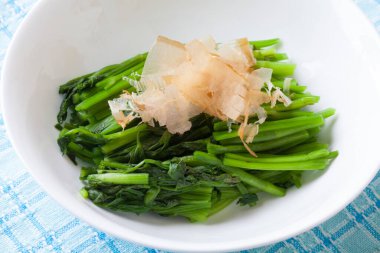 Buharda pişmiş yeşil sebzeler ve bonito taneleri.