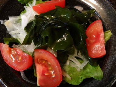 Bir kase salata, domates, salatalık ve marul. 