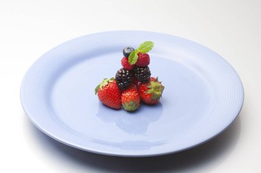 Beyaz arka planda taze olgun çilek tabağı