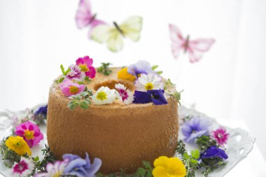 Çiçeklerle süslenmiş lezzetli doğum günü pastasının yakın plan görüntüsü.       